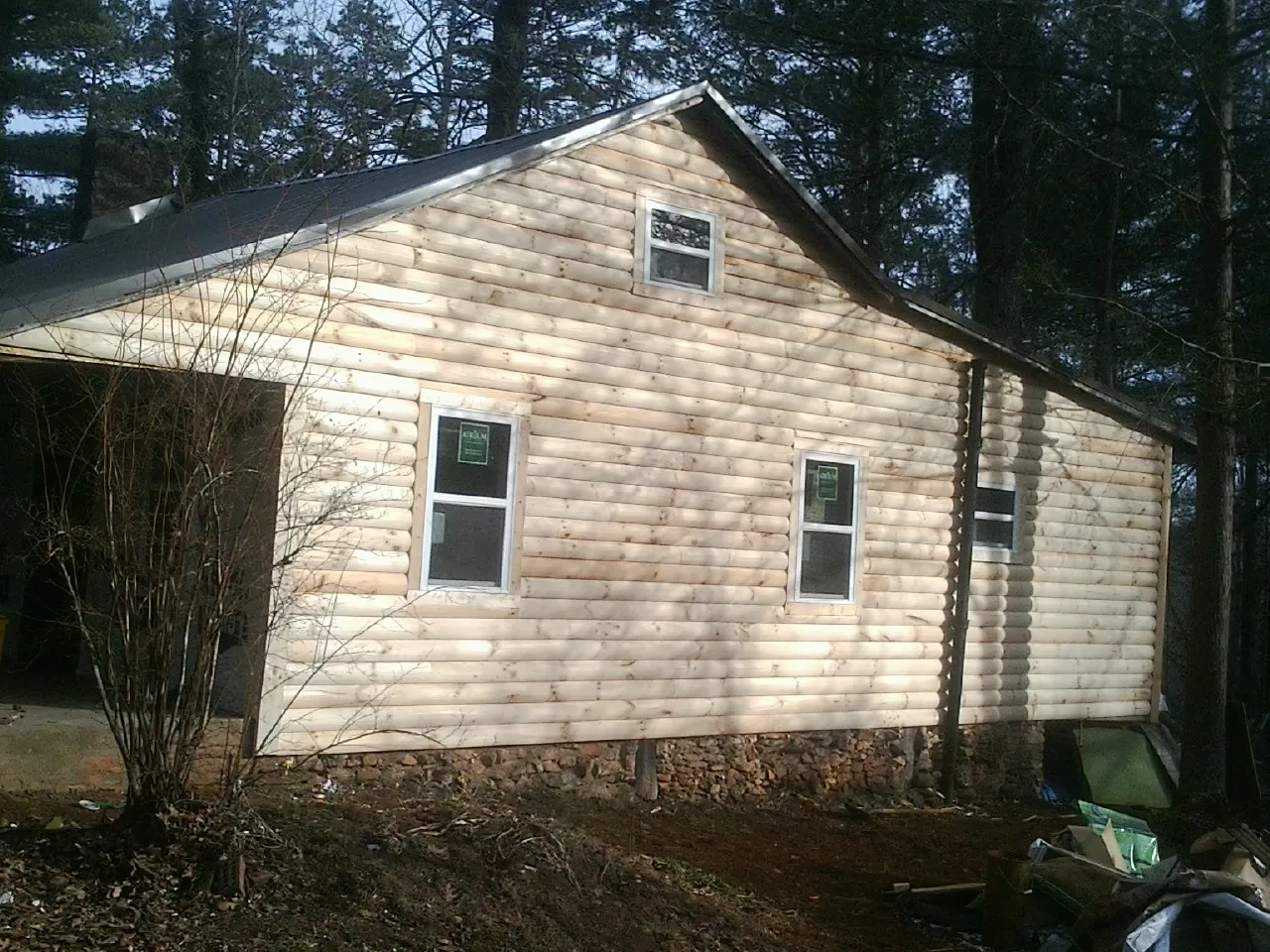 New log siding and dark metal roofing on a gable end in Acworth