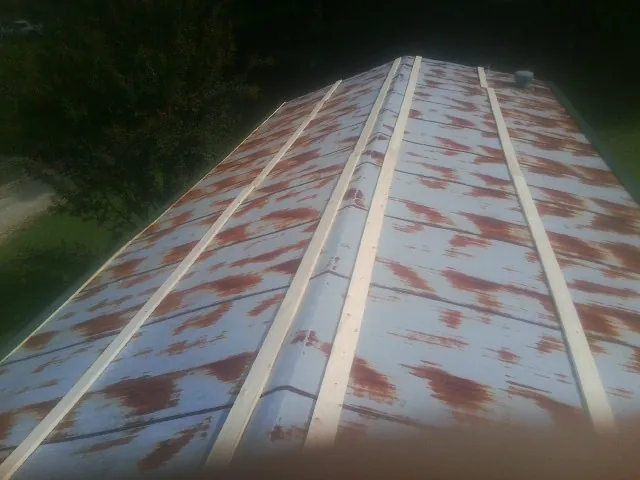 Rusted metal roof panels with new wood purlins before replacement — Storm Damage Roof Repair in Acworth by Roofing Brothers